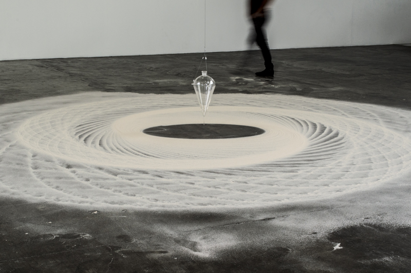 Instalação Movimento Pendular de Felippe Moraes com pêndulo desenhando curvas na areia.