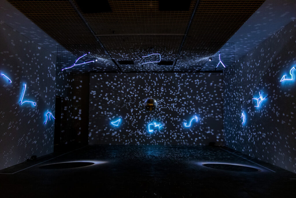 Solaris Discotecum (2023), instalação de Felippe Moraes com constelações do zodíaco em néon e globo espelhado representando o sistema solar