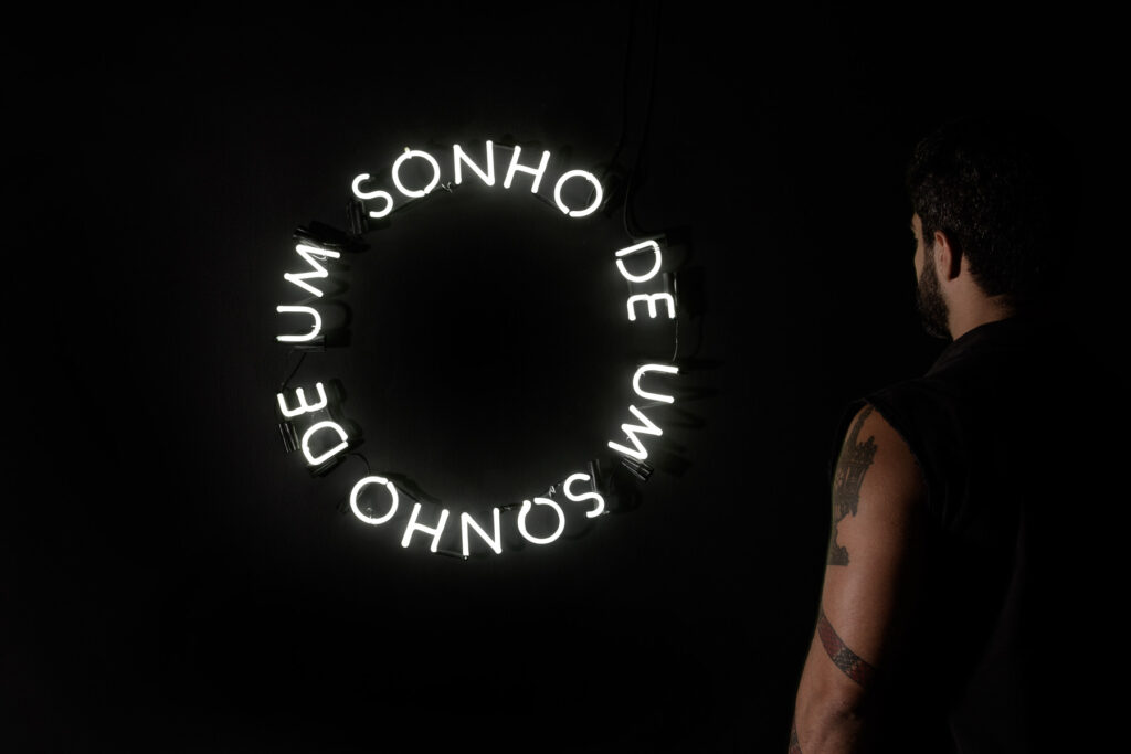 Letreiro em néon circular com a frase “Sonho de um sonho”, obra de Felippe Moraes inspirada em samba-enredo de Martinho da Vila