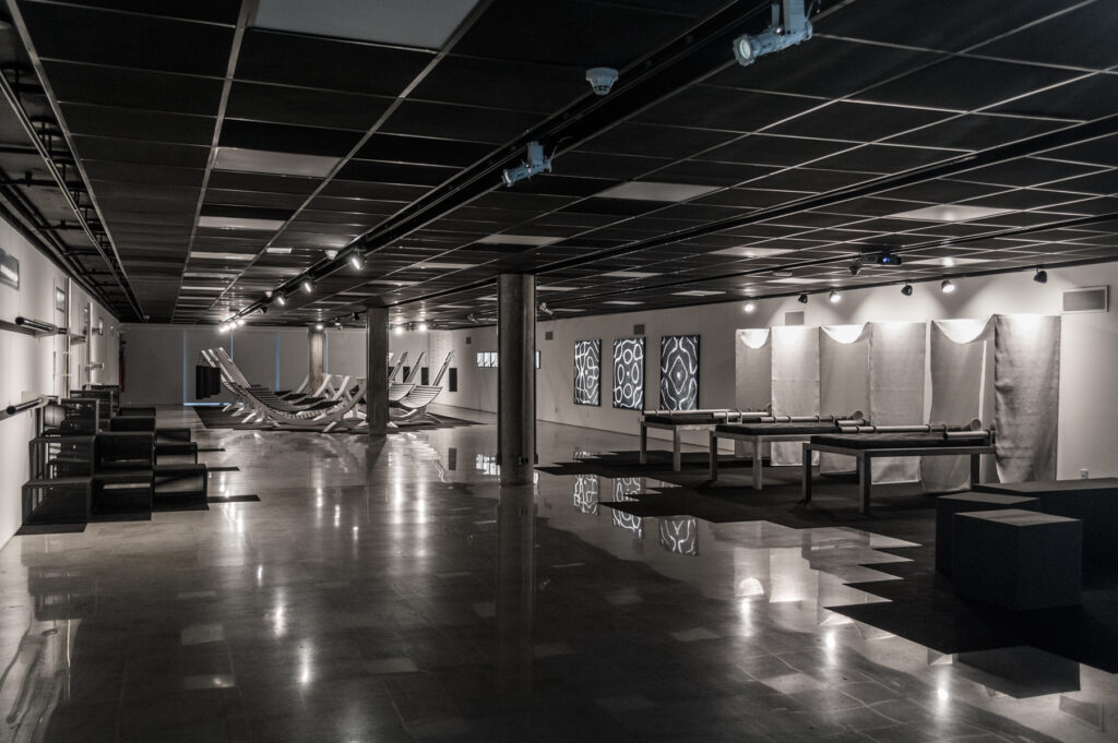 vista geral da exposição imersiva de Felippe Moraes com redes, estruturas sonoras e luz em espaço expositivo