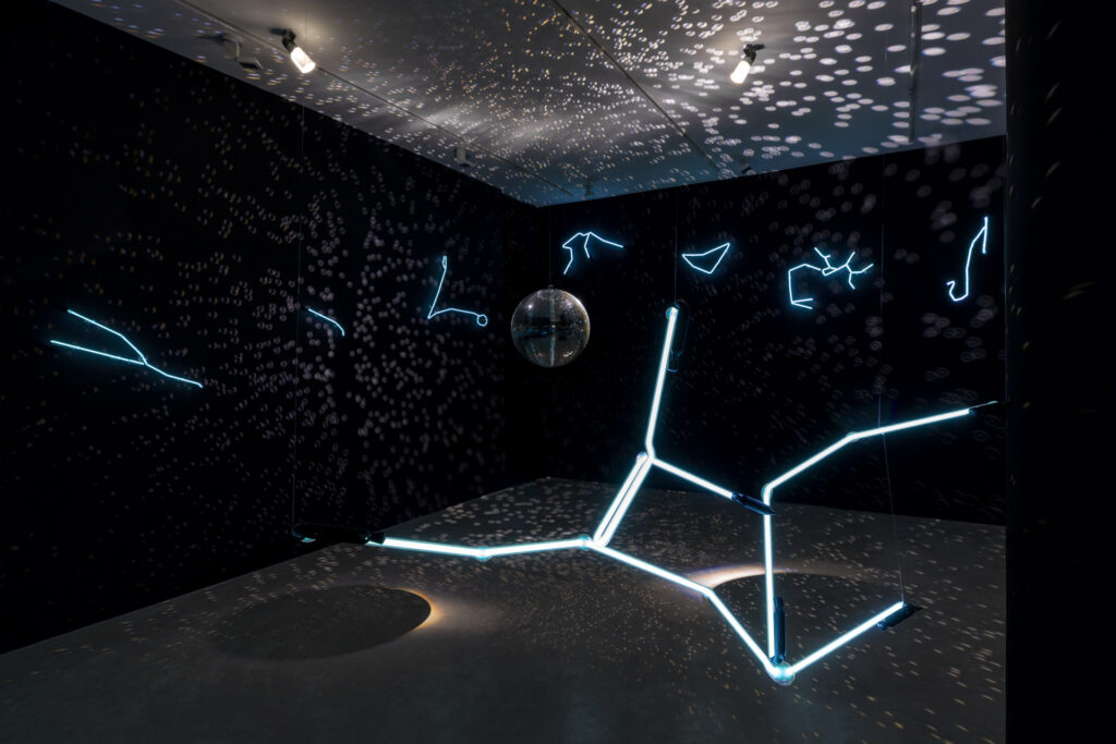 Solaris Discotecum (2023), instalação de Felippe Moraes com constelações do zodíaco em néon e globo espelhado representando o sistema solar