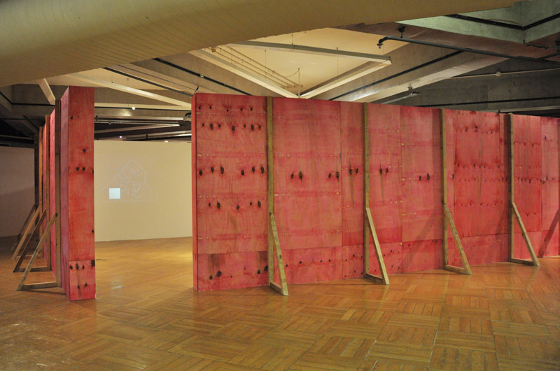 Tapumes magenta com projeção de vídeos da série Encarnado na exposição Construção de Felippe Moraes no Paço das Artes.