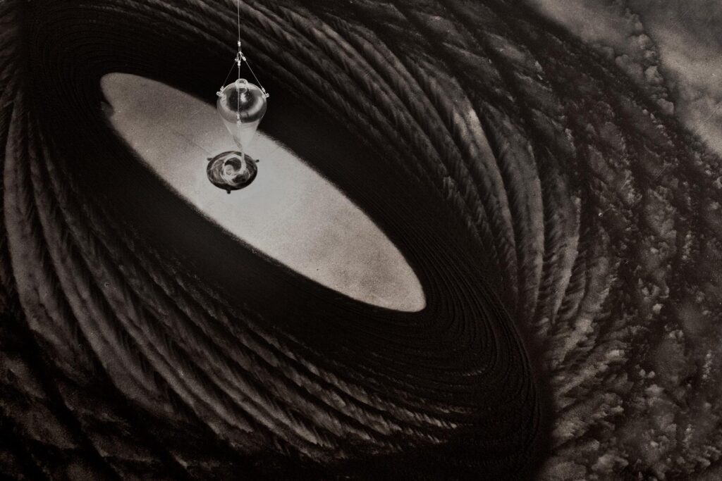 Instalação Movimento Pendular de Felippe Moraes com pêndulo desenhando curvas na areia.