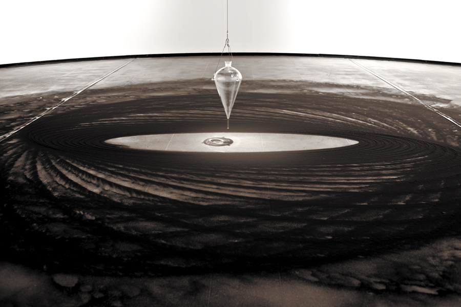 Instalação Movimento Pendular de Felippe Moraes com pêndulo desenhando curvas na areia.