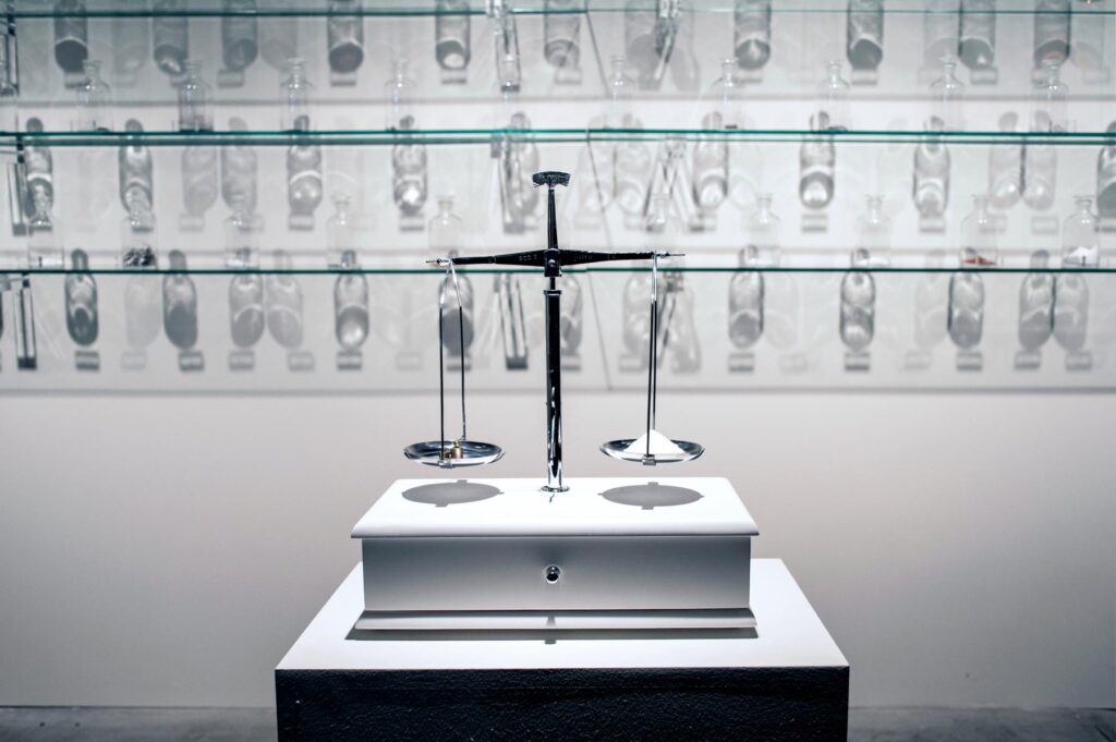 Instalação O Peso do Verbo de Felippe Moraes com recipientes contendo materiais condutores de eletricidade.