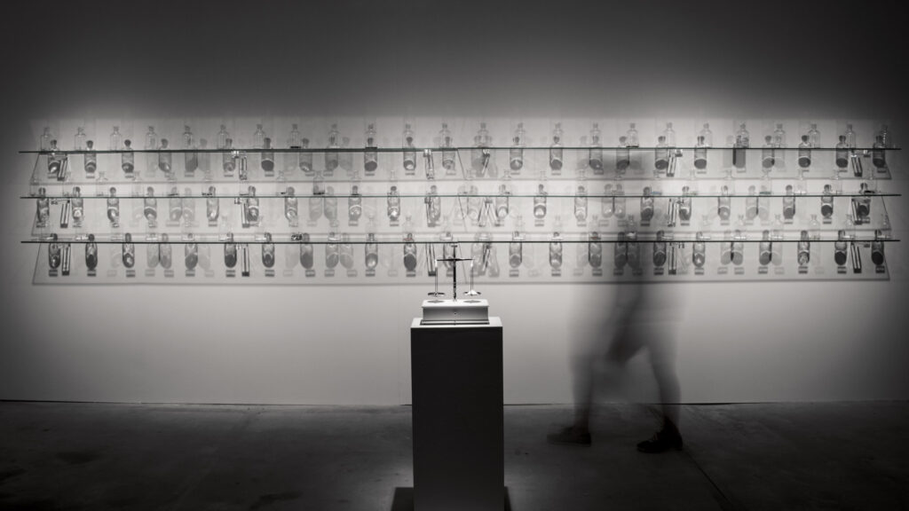 Instalação O Peso do Verbo de Felippe Moraes com recipientes contendo materiais condutores de eletricidade.