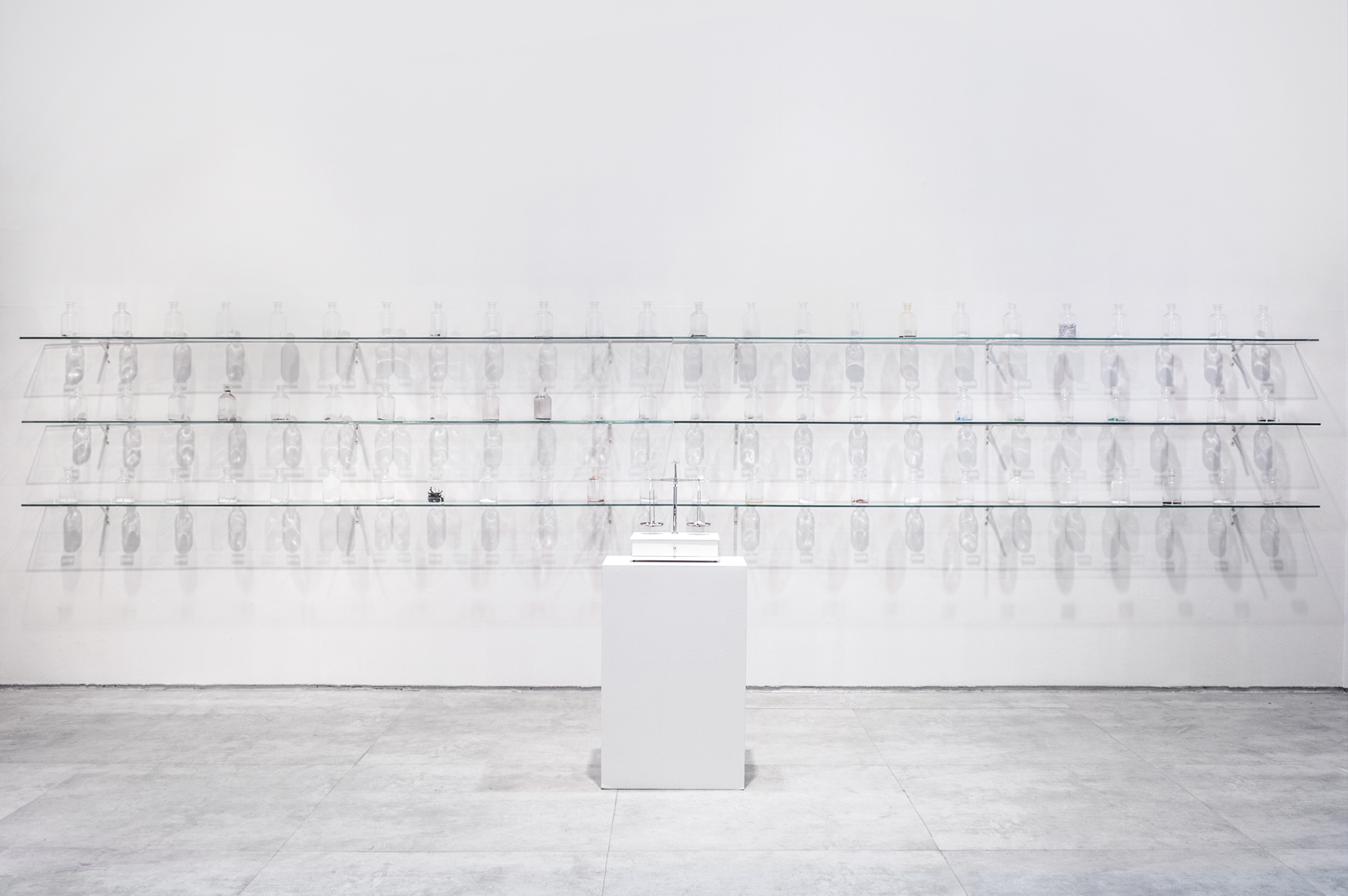 Instalação O Peso do Verbo de Felippe Moraes com recipientes contendo materiais condutores de eletricidade.