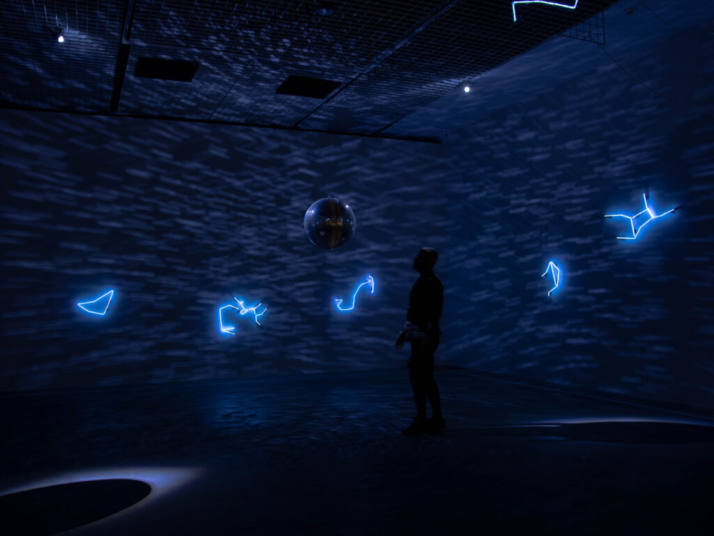 Solaris Discotecum (2023), instalação de Felippe Moraes com constelações do zodíaco em néon e globo espelhado representando o sistema solar