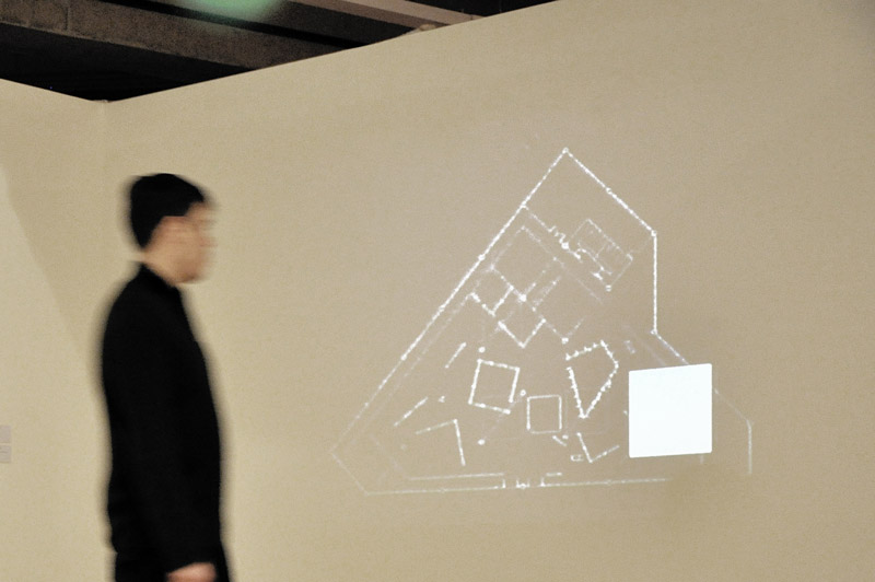 Projeção de quadrado de luz sobre planta do espaço expográfico na parede na obra Quatro Paredes Mágicas de Felippe Moraes.