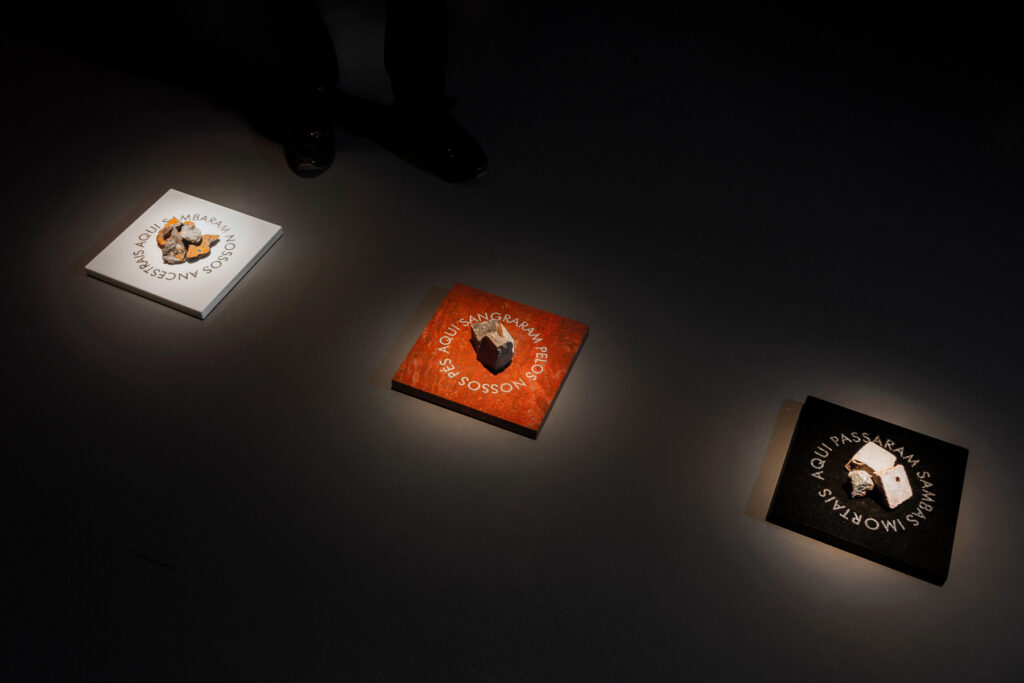 Escultura Aqui Passaram (2025) de Felippe Moraes com gravação a laser sobre pedra e fragmentos das avenidas Marquês de Sapucaí, Rio Branco e Presidente Vargas.