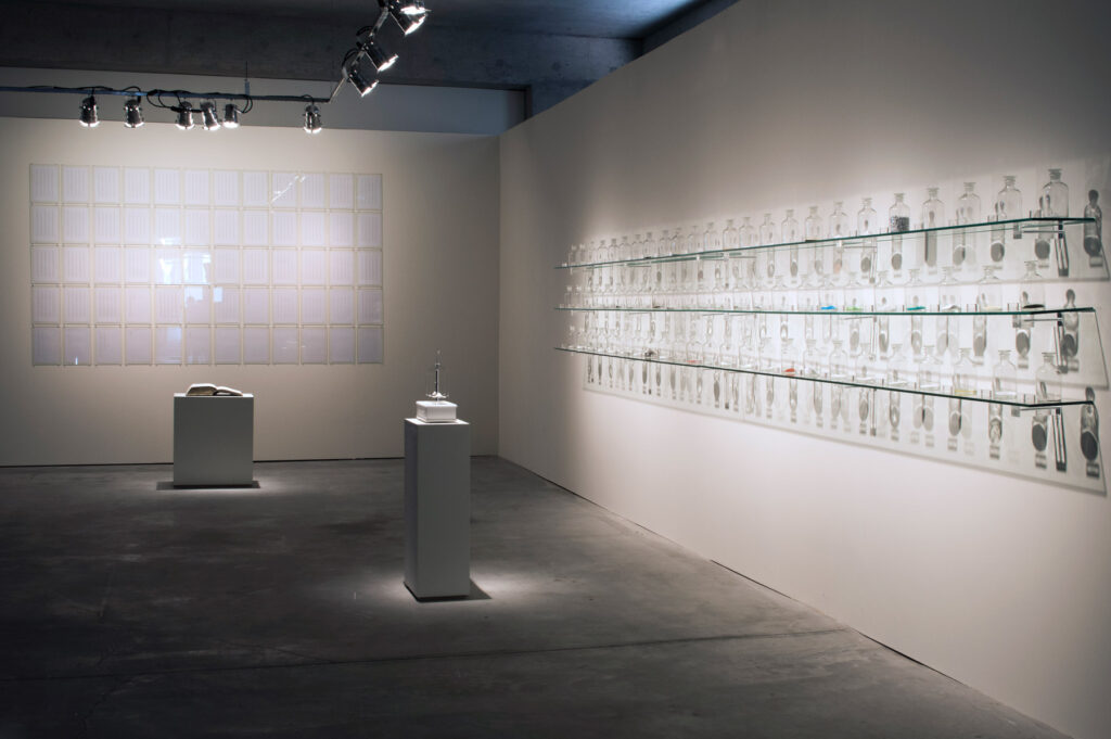 Instalação O Peso do Verbo de Felippe Moraes com recipientes contendo materiais condutores de eletricidade e Instalação O Peso do Verbo de Felippe Moraes com recipientes contendo materiais condutores de eletricidade.