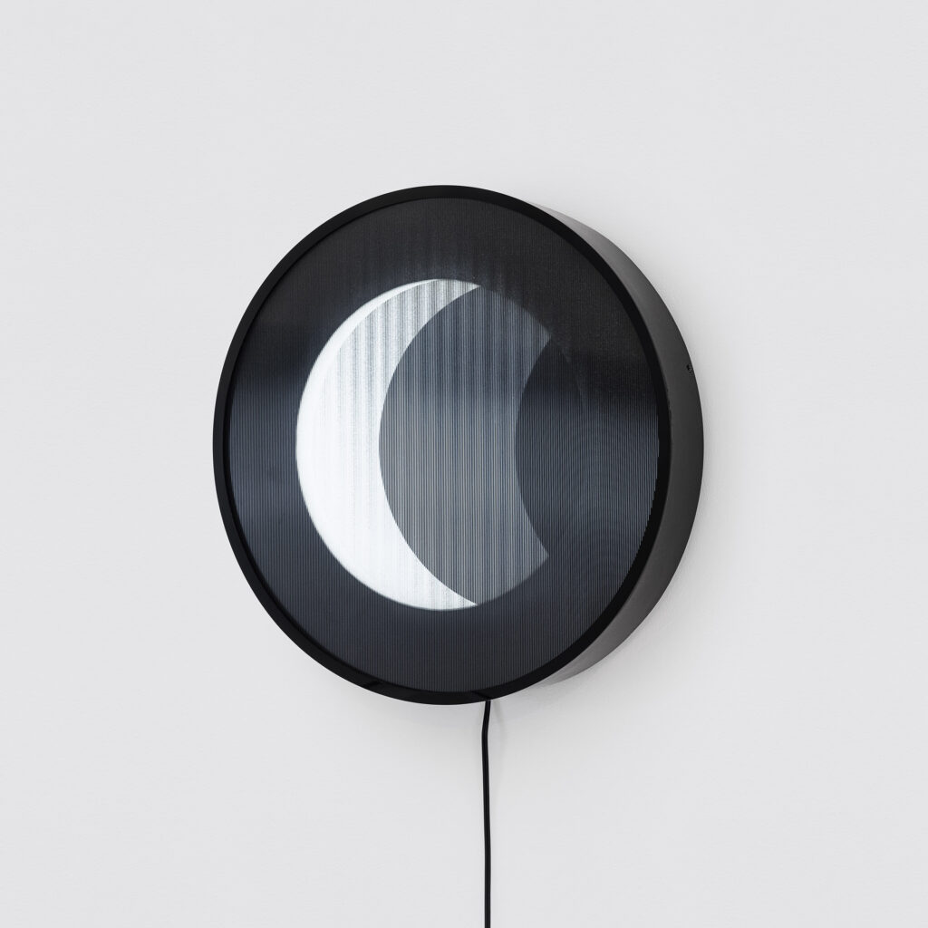 Obra Eclipse (2025) de Felippe Moraes com impressão lenticular circular retroiluminada representando eclipse solar.